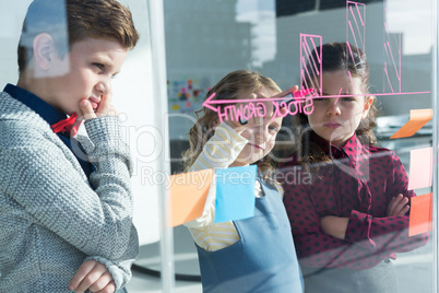 Colleagues planning while writing on window