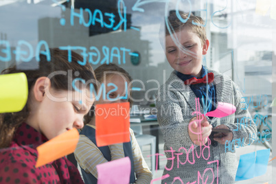 Business people discussing data at office seen through glass