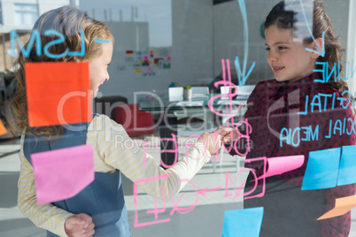 Female colleagues giving handshake seen through glass