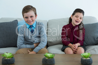 Portrait of happy business people relaxing on sofa at office