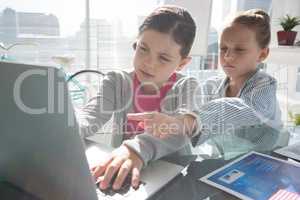 Female coworkers discussing over laptop at desk