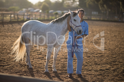 Full length portrait of vet standing by horse