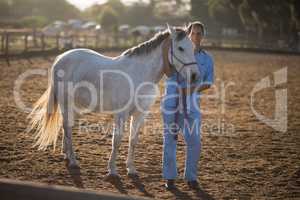 Full length portrait of vet standing by horse