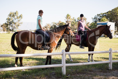 Portrait of female friends horseback riding