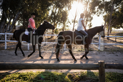 Friends riding horses at barn