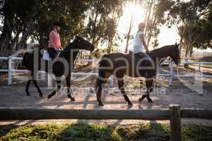 Friends riding horses at barn