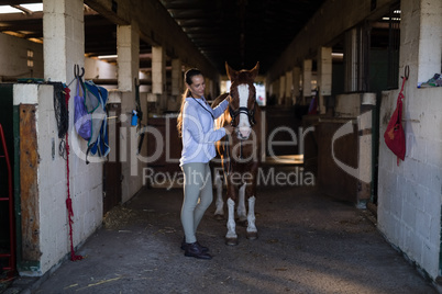 Female vet examining horse at stable
