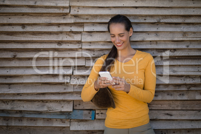 Female jockey using smart phone by stable