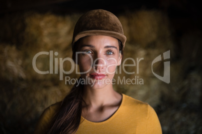 Portrait of serious female jockey in stable
