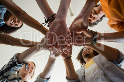 Low angle view of friends stacking hands