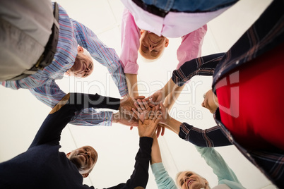 Directly below shot of happy senior friends stacking hands