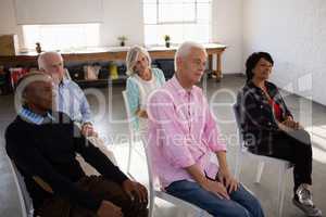 Attentive senior people sitting on chair