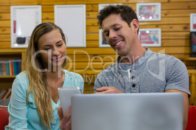 Man showing mobile phone to girlfriend in coffee shop