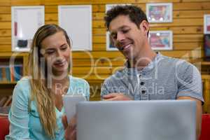 Man showing mobile phone to girlfriend in coffee shop