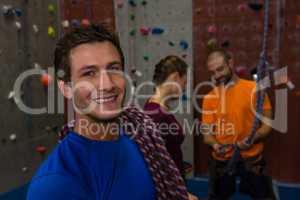 Portrait of man carrying climbing rope in gym