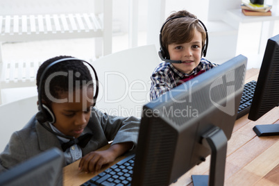 Portrait of businessman talking through headset at desk