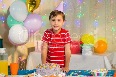 Cute boy standing with birthday cake