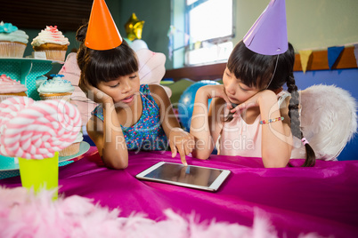 Little girls using tablet at party