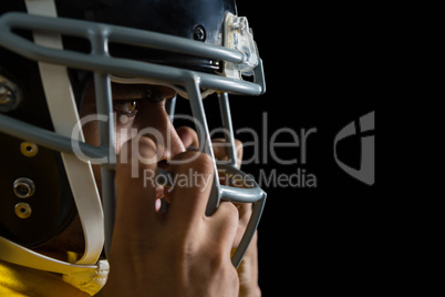 American football player holding a head gear on his head
