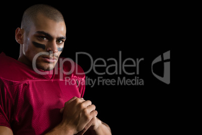 Determined American football player against a black background