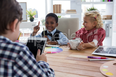 Businessman using digital tablet while discussing with colleagues