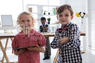 Portrait of confident colleagues with businessman in background at office