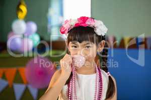 Portrait of cute girl drinking tea during birthday party