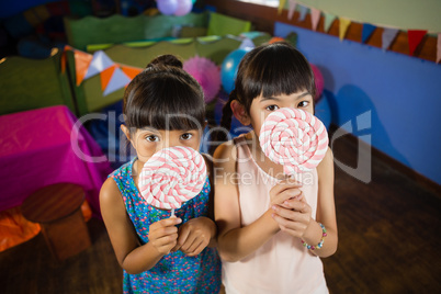 Kids holding a lollipop during birthday party at home