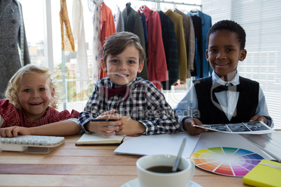 Portrait of confident business people standing at table in office