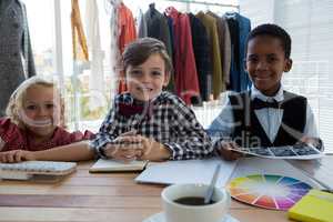 Portrait of confident business people standing at table in office