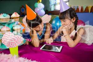 Little girls using tablet at party