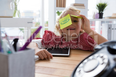 Port5rait of playful businesswoman with adhesive notes on eyes at office