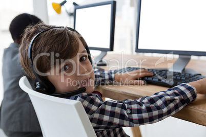 Portrait of businessman working with coworker at desk