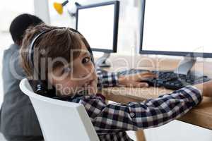 Portrait of businessman working with coworker at desk