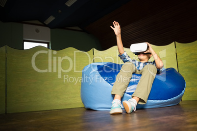 Boy sitting on bean bag and using virtual reality headset