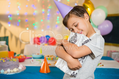 Boy embracing gift box during birthday party