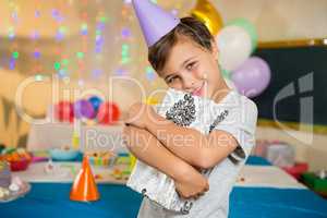 Boy embracing gift box during birthday party at home