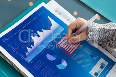 Cropped hand of businessman analyzing data in office