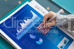 Cropped hand of businessman analyzing data in office