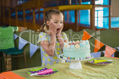Surprised girl looking at birthday cake