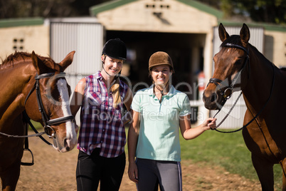 Portrait of smiling friends with horses