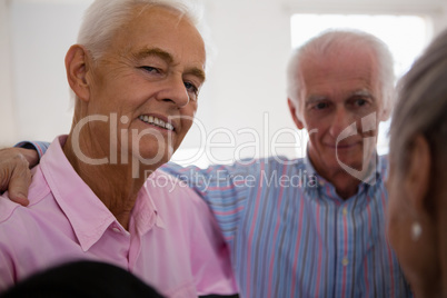 Portrait of senior man huddling with friends