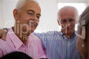 Portrait of senior man huddling with friends