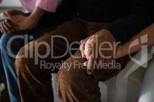 High angle view of senior friends holding hands while sitting on chair