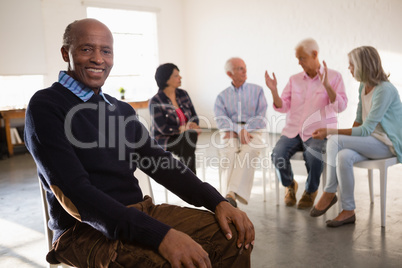 Portrait of smiling senior man with friends in background