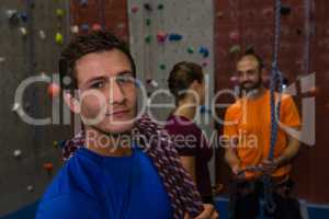 Portrait of confident man with climbing rope in gym