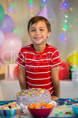 Cute boy standing with birthday cake