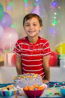 Cute boy standing with birthday cake