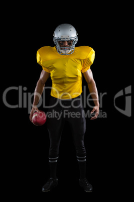 American football player holding a ball in one hand