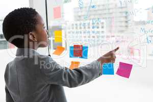 Rear view of businessman analyzing data on window at office